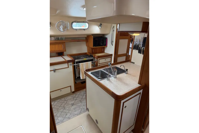  Yacht Photos Pics 2008 Island Packet SP Cruiser kitchen with dual sinks, stove, and wooden cabinetry.