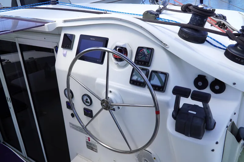 Red Yacht Photos Pics Helm of 2008 Fountaine Pajot Orana 44 catamaran with navigation instruments and steering wheel.