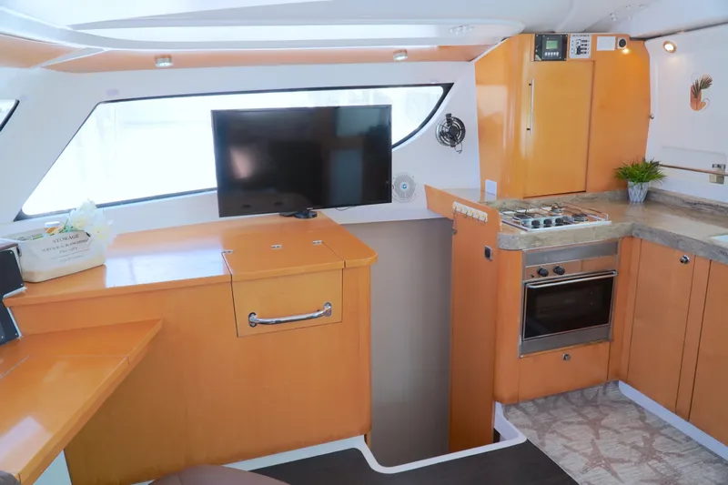 Red Yacht Photos Pics Interior of 2008 Fountaine Pajot Orana 44 catamaran with modern kitchen and TV.