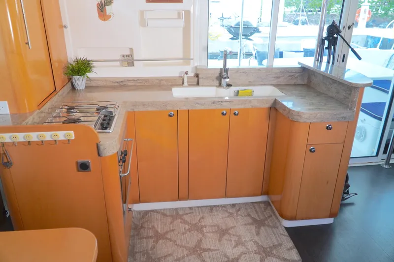 Red Yacht Photos Pics 2008 Fountaine Pajot Orana 44 yacht kitchen with orange cabinets and modern appliances.