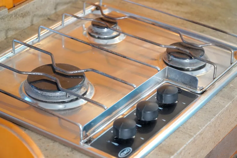 Red Yacht Photos Pics Three-burner stove on 2008 Fountaine Pajot Orana 44 catamaran kitchen countertop.