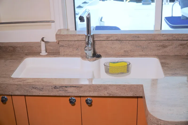 Red Yacht Photos Pics Modern kitchen sink on 2008 Fountaine Pajot Orana 44 catamaran with marble countertop.
