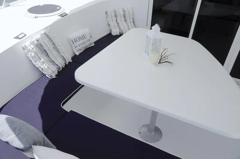 Red Yacht Photos Pics Cozy seating area on 2008 Fountaine Pajot Orana 44 catamaran with cushions and table.