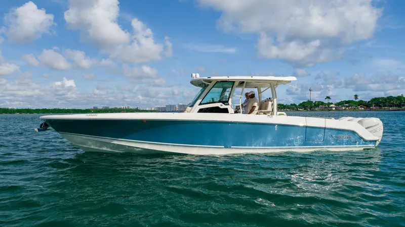  Yacht Photos Pics 2019 Boston Whaler 380 Outrage boat on calm water under a partly cloudy sky.