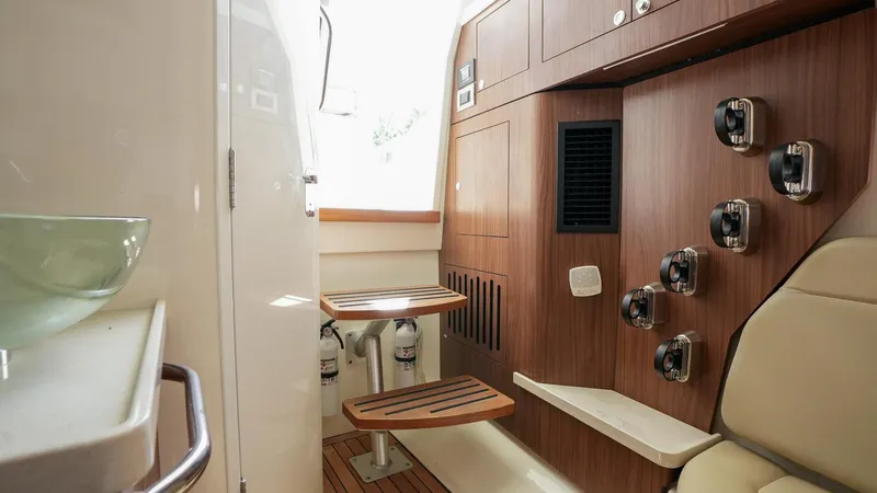  Yacht Photos Pics 2019 Boston Whaler 380 Outrage cabin interior with wooden accents and seating.