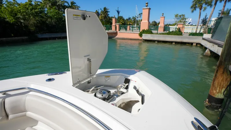  Yacht Photos Pics 2019 Boston Whaler 380 Outrage boat with open storage compartment, docked by a waterfront.