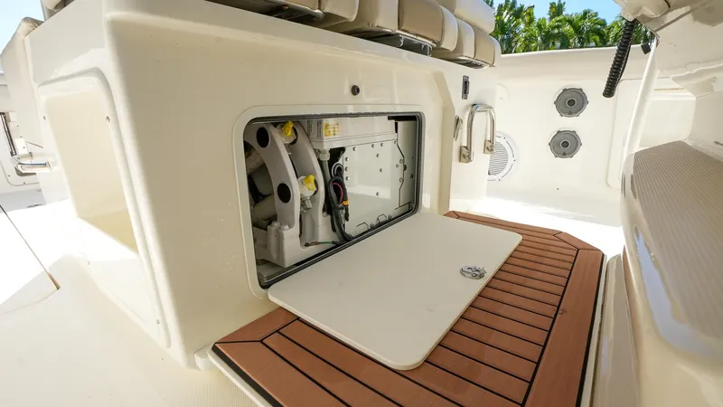  Yacht Photos Pics 2019 Boston Whaler 380 Outrage boat storage compartment with open hatch and teak flooring.