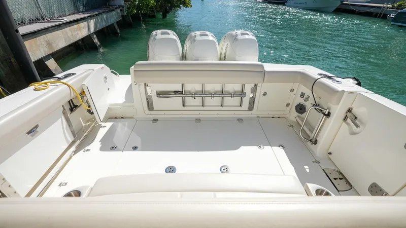  Yacht Photos Pics 2019 Boston Whaler 380 Outrage boat deck with triple engines, docked on clear water.