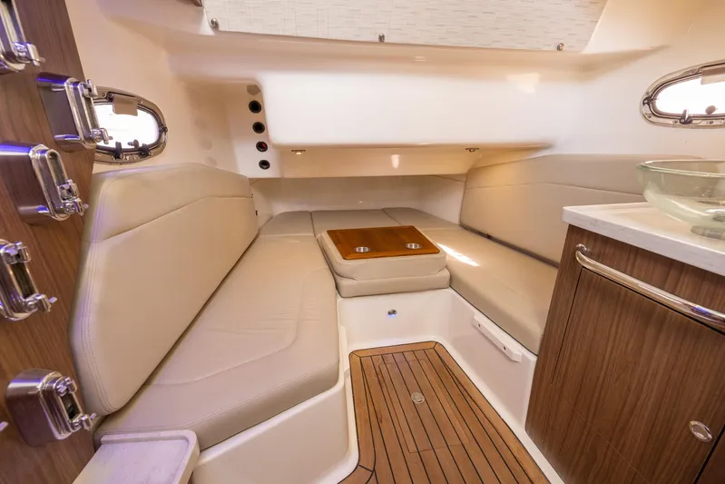  Yacht Photos Pics 2019 Boston Whaler 380 Outrage cabin interior with beige seating and wooden accents.