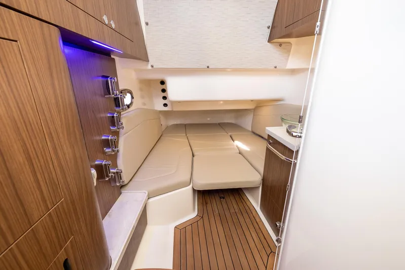  Yacht Photos Pics 2019 Boston Whaler 380 Outrage cabin interior with wood accents and cushioned seating.