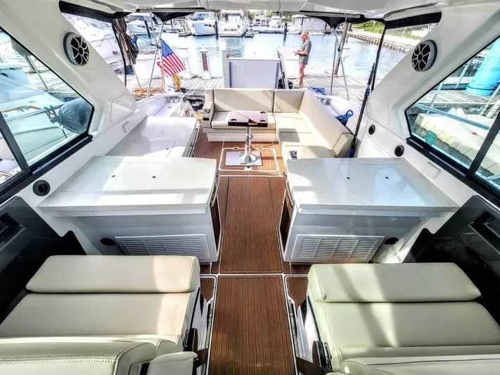  Yacht Photos Pics 2017 Monterey 360 Sport Coupe interior with seating, tables, and dock view.