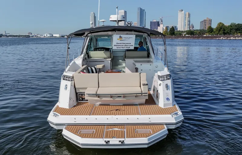  Yacht Photos Pics 2017 Monterey 360 Sport Coupe on water with city skyline in background.