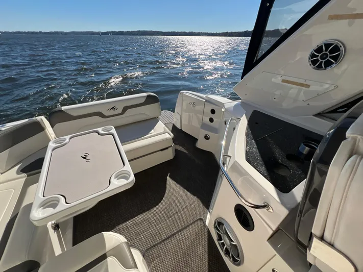  Yacht Photos Pics 2014 Monterey 320 Sport Yacht interior with seating and table, overlooking sunny waters.