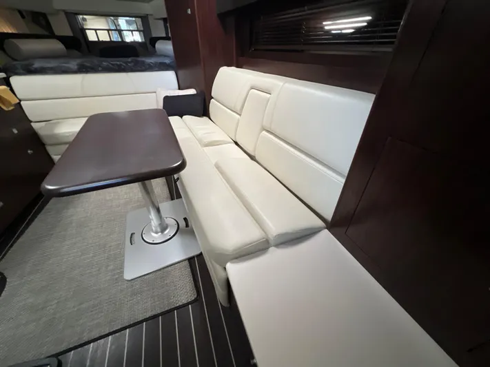  Yacht Photos Pics 2014 Monterey 320 Sport Yacht interior with white leather seating and dark wood table.