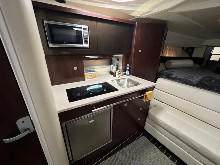  Yacht Photos Pics 2014 Monterey 320 Sport Yacht interior kitchen with microwave, sink, and seating area.