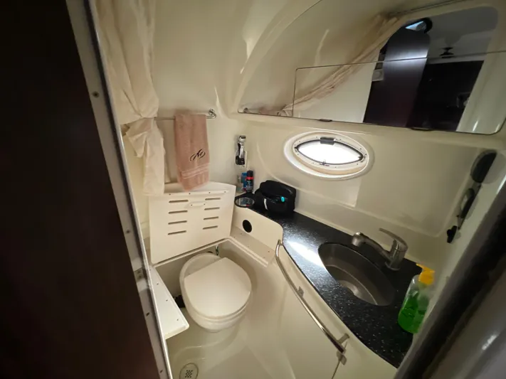  Yacht Photos Pics Bathroom interior of 2014 Monterey 320 Sport Yacht with sink, toilet, and porthole window.
