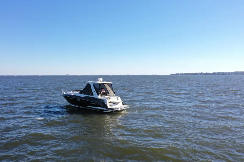  Yacht Photos Pics 2014 Monterey 320 Sport Yacht cruising on open water under clear blue sky.