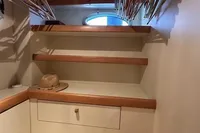 Walk-in closet with shelves and hangers on a 2005 Pershing 76 yacht.