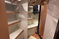 Walk-in closet with wooden shelves and hangers on a Pershing 76 yacht, 2005 model.