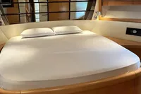 Luxurious bedroom interior of 2005 Pershing 76 yacht with elegant bedding and modern design.
