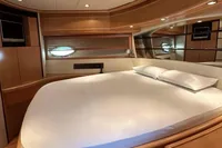 Luxurious bedroom interior of 2005 Pershing 76 yacht with elegant wood finishes.