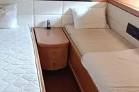 Interior of 2005 Pershing 76 yacht with twin beds and wooden furnishings.