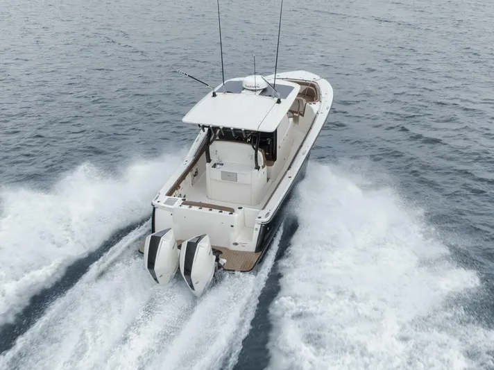 T/t Phoenix Yacht Photos Pics 2023 Scout 330 LXF boat cruising on open water, rear view with twin engines.