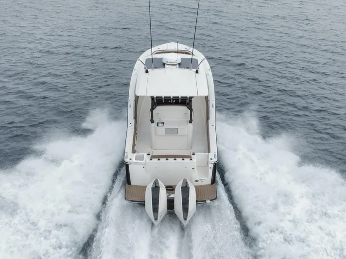 T/t Phoenix Yacht Photos Pics 2023 Scout 330 LXF boat cruising on open water, rear view.