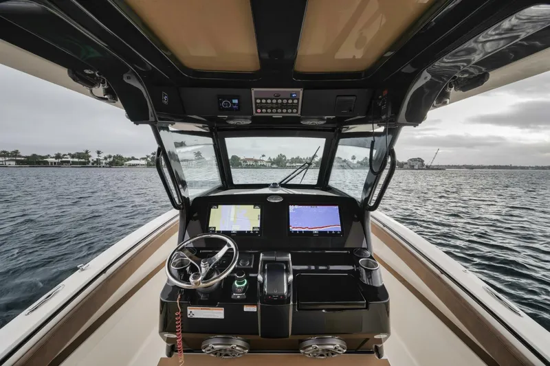 T/t Phoenix Yacht Photos Pics 2023 Scout 330 LXF boat cockpit with dual navigation screens on open water.
