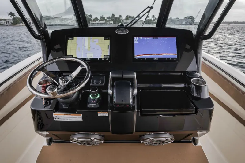 T/t Phoenix Yacht Photos Pics 2023 Scout 330 LXF boat dashboard with navigation screens and steering wheel.