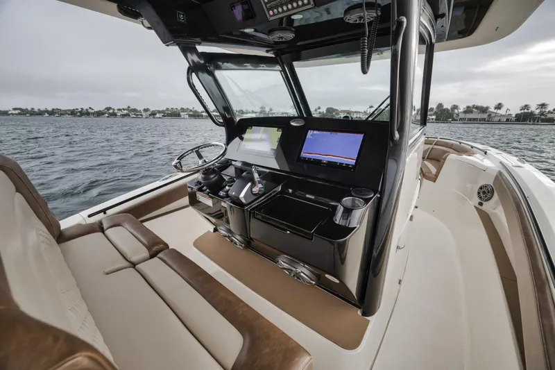 T/t Phoenix Yacht Photos Pics 2023 Scout 330 LXF boat interior with modern dashboard and seating on the water.