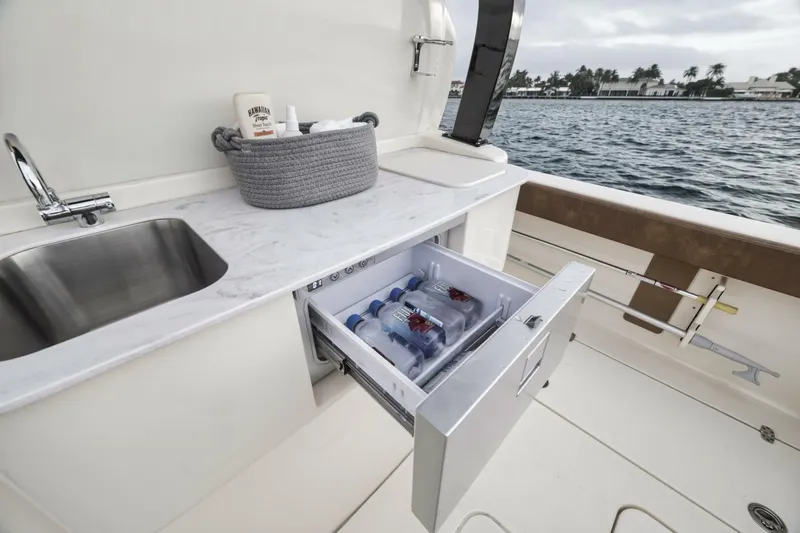 T/t Phoenix Yacht Photos Pics 2023 Scout 330 LXF boat with open drawer fridge and sink by the water.