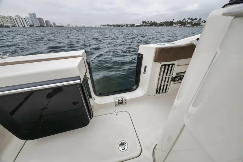 T/t Phoenix Yacht Photos Pics 2023 Scout 330 LXF boat interior with open door, overlooking water and cityscape.