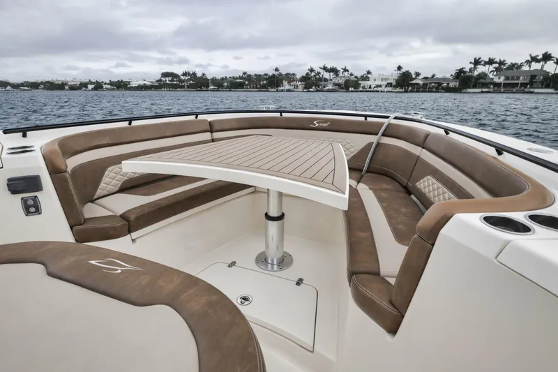 T/t Phoenix Yacht Photos Pics 2023 Scout 330 LXF boat interior with cushioned seating and table on water.