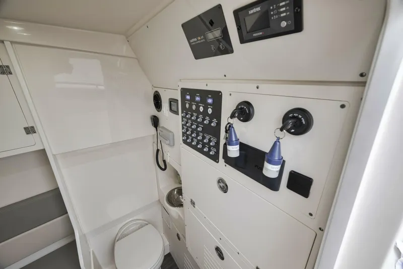T/t Phoenix Yacht Photos Pics 2023 Scout 330 LXF interior with control panel, toilet, and storage compartments.