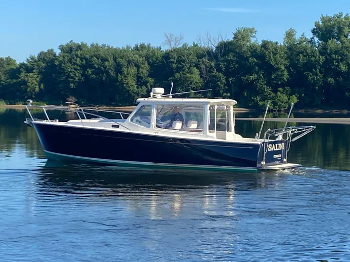 Saline Yacht Photos Pics 2005 MJM 34z Downeast boat cruising on calm water with forested shoreline.