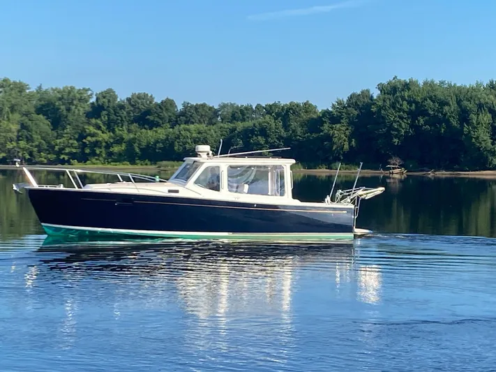 Saline Yacht Photos Pics 2005 MJM 34z Downeast boat on calm water with forested background.