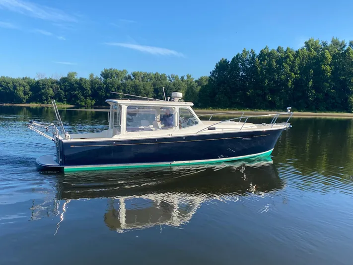 Saline Yacht Photos Pics 2005 MJM 34z Downeast boat cruising on a calm lake with forested shoreline.