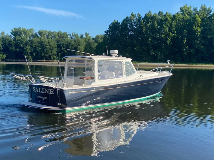 Saline Yacht Photos Pics 2005 MJM 34z Downeast boat cruising on calm water with lush green trees in the background.