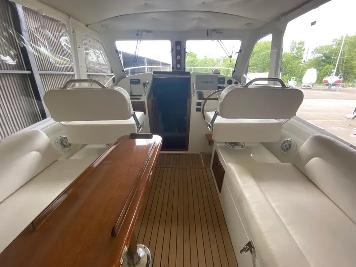 Saline Yacht Photos Pics Interior of 2005 MJM 34z Downeast boat with white seating and wooden table.