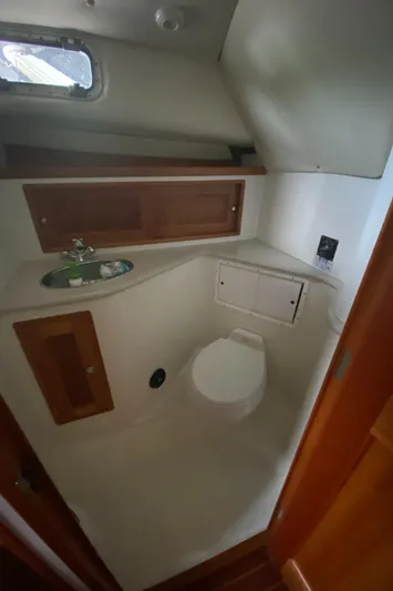 Saline Yacht Photos Pics 2005 MJM 34z Downeast boat bathroom with sink, toilet, and wooden cabinetry.