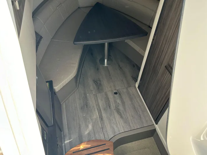  Yacht Photos Pics 2021 Sea Ray 320 DA cabin interior with wood flooring and triangular table.