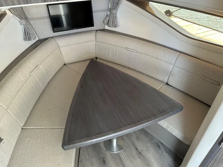 Yacht Photos Pics Sea Ray 320 DA 2021 interior with triangular table and cushioned seating.