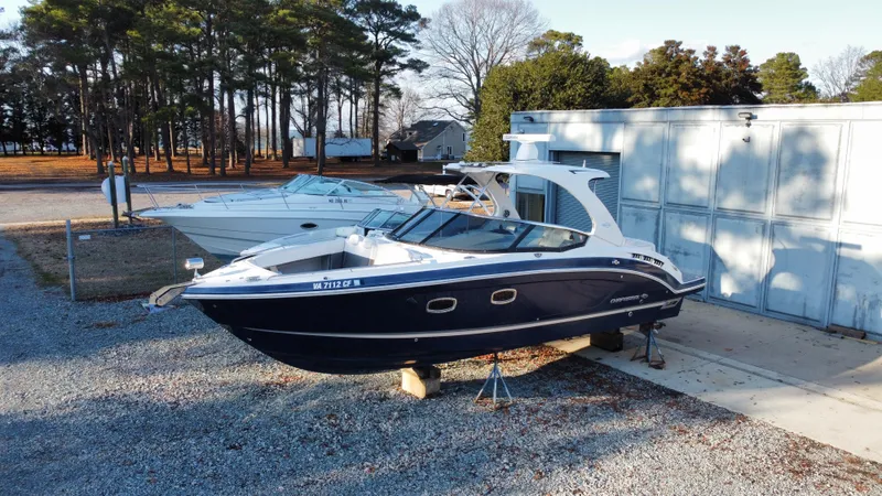  Yacht Photos Pics 2016 Chaparral 337SSX boat on stands, parked outdoors near trees and a building.