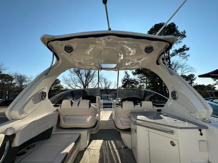  Yacht Photos Pics 2016 Chaparral 337SSX boat interior with seating and kitchenette under a clear blue sky.