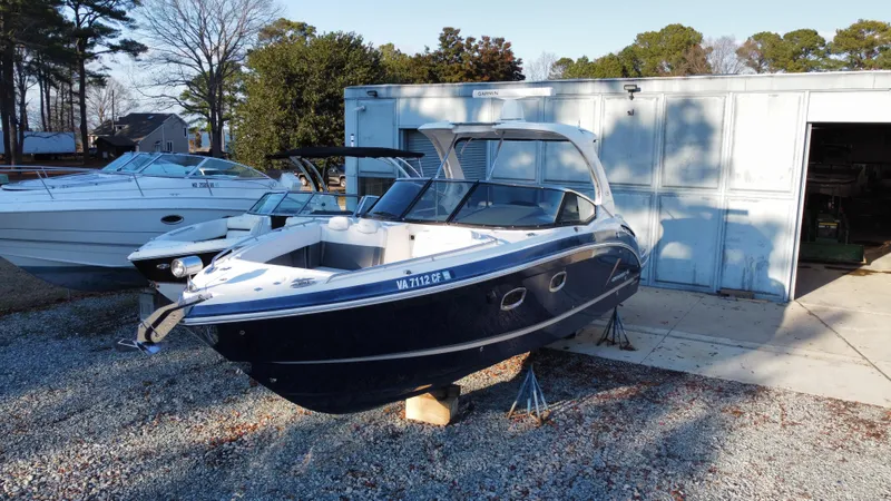  Yacht Photos Pics 2016 Chaparral 337SSX boat on stands near a storage building.