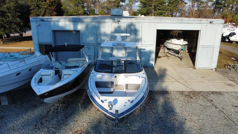  Yacht Photos Pics 2016 Chaparral 337SSX boat parked outside a storage facility with other boats nearby.