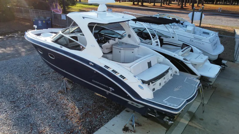  Yacht Photos Pics 2016 Chaparral 337SSX boat in a marina, side view, parked on gravel.