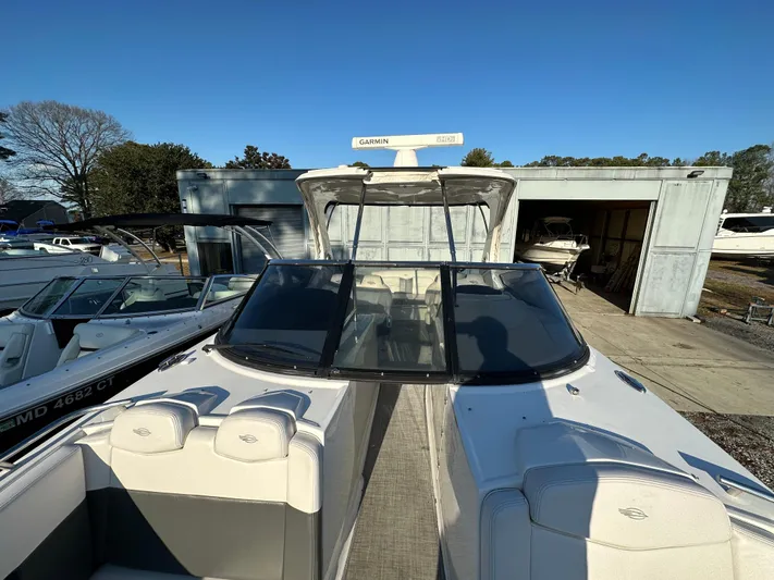  Yacht Photos Pics 2016 Chaparral 337SSX boat docked near a storage facility under clear blue skies.