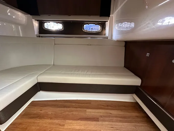  Yacht Photos Pics Interior of 2016 Chaparral 337SSX boat with white seating and wood flooring.